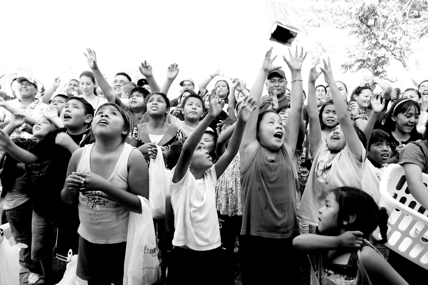 Still from GRAB (2011): children at the Laguna Pueblo Grab Day celebration, hands raised to the sky.